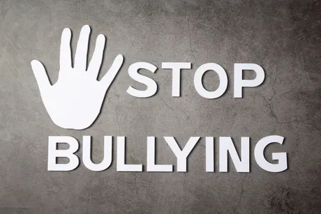word-stop-bullying-with-hand-sign-dark-wall.jpg